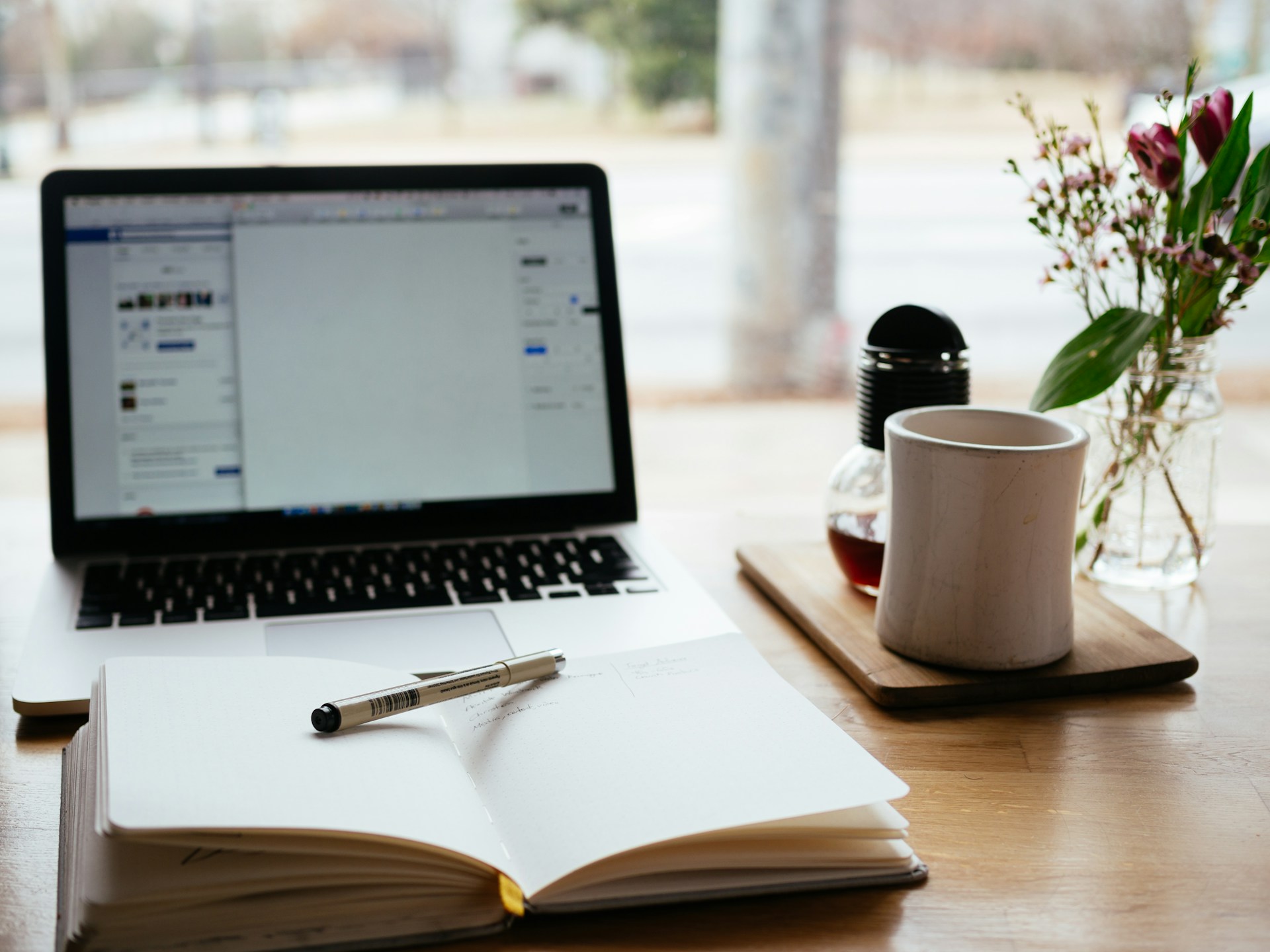 Open notebook and laptop on a warm writing desk